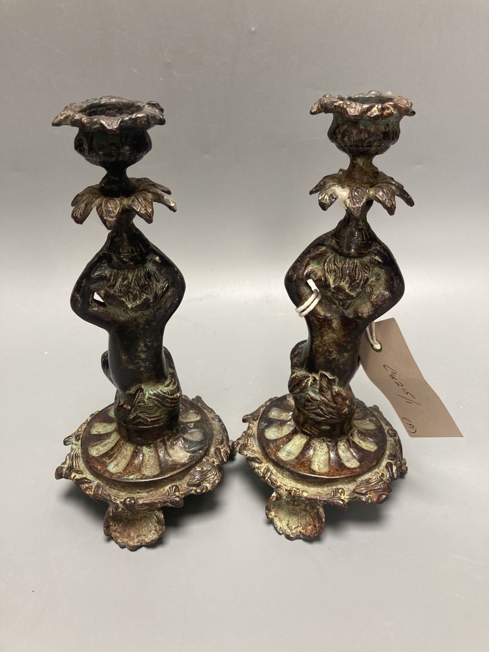 Two patinated metal putti candlesticks, height 20cm